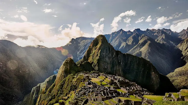 Vista clásica de Machu Picchu con las ruinas incas y montañas verdes alrededor.