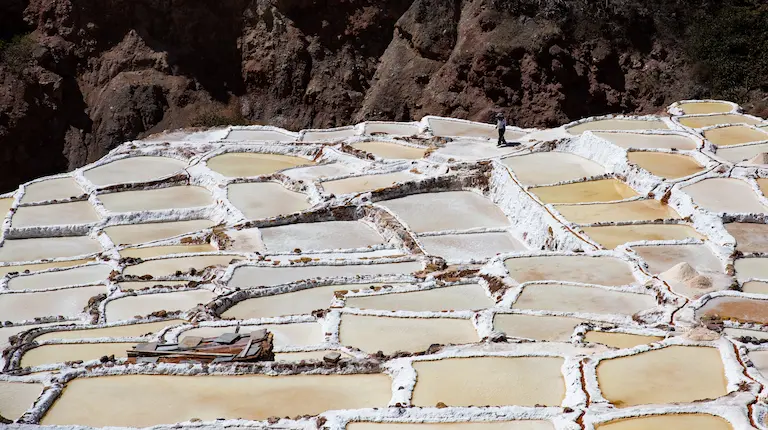Vista panorámica de las piscinas de sal de las Salineras de Maras, en tonos blancos y rosados.